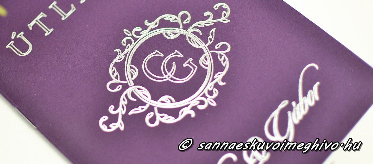 Csillogó ezüst monogram a meghívó borító oldalán